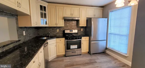 a kitchen with granite countertop white cabinets and stainless steel appliances