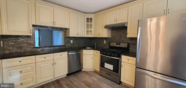 a kitchen with granite countertop white cabinets and black appliances
