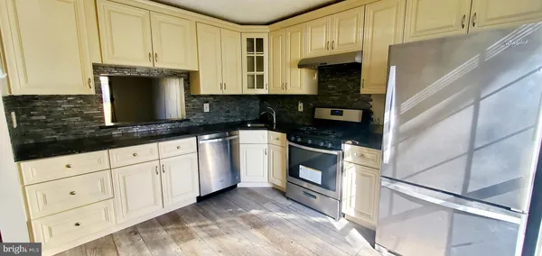 a kitchen with a refrigerator and a stove top oven