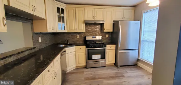 a kitchen with granite countertop a stove and cabinets