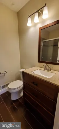 a bathroom with a toilet a sink and mirror