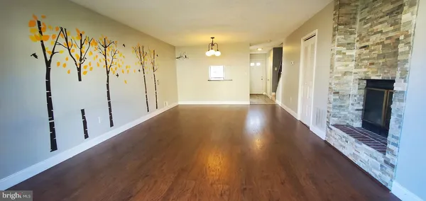 a view of a hallway with wooden floor and a bathroom