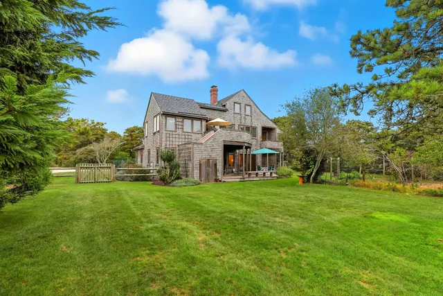 a view of a big house with a big yard and large trees