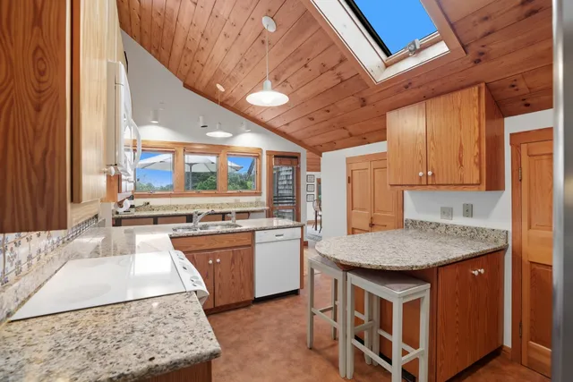 a kitchen with stainless steel appliances kitchen island granite countertop a table chairs in it and wooden floors