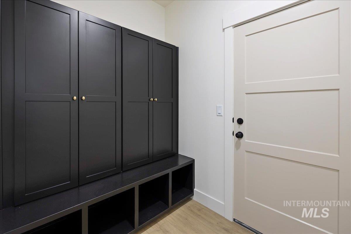2005 Sparrow Street Rupert, ID 83350 - Photo 27 of 30 Built-in dark cabinetry featuring gold-toned hardware, integrated open shelving, and a coordinating dark bench