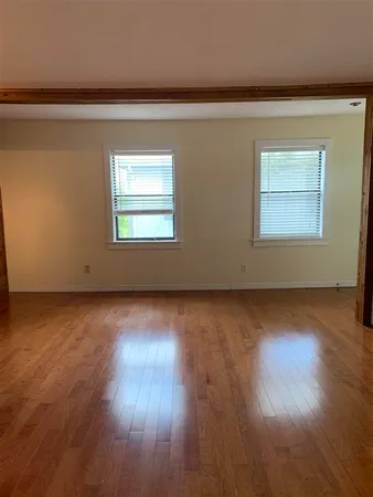 a view of empty room with wooden floor and fireplace