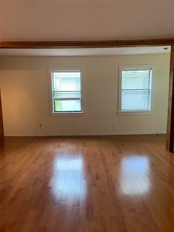 a view of empty room with wooden floor and fireplace
