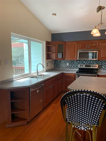 a kitchen with stainless steel appliances granite countertop a stove a sink dishwasher and a refrigerator