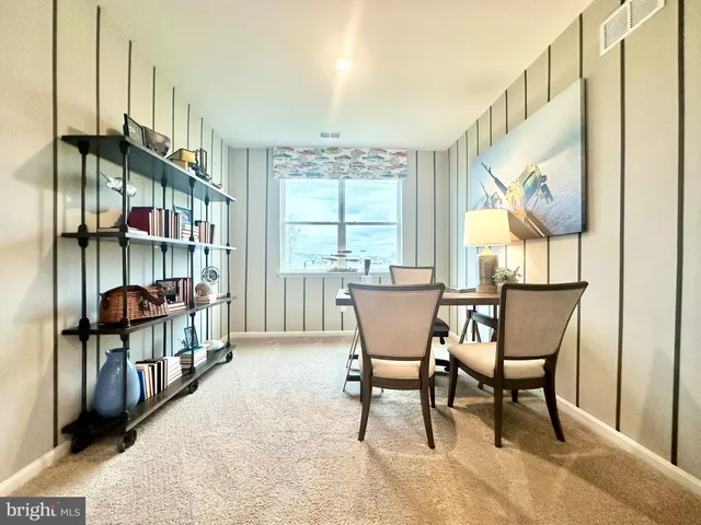 a dining room with furniture and a floor to ceiling window