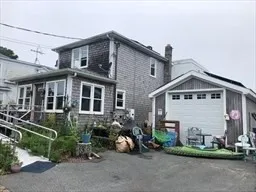 a view of a house with a yard and lawn chairs