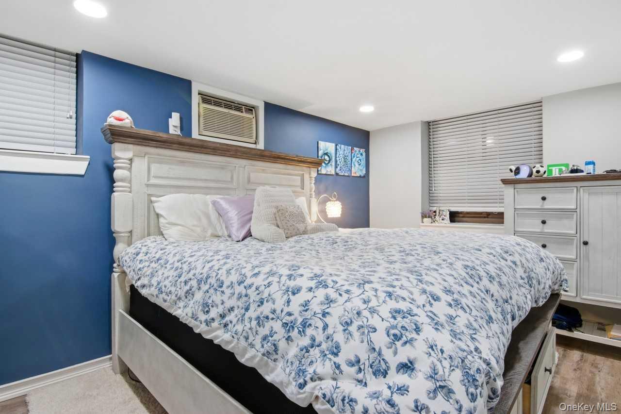 52 Brompton Road, Unit 52 Great Neck, NY 11021 - Photo 12 of 17 a bedroom with a large bed and a dresser