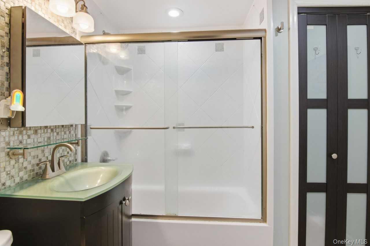 52 Brompton Road, Unit 52 Great Neck, NY 11021 - Photo 14 of 17 a bathroom with a sink and a mirror