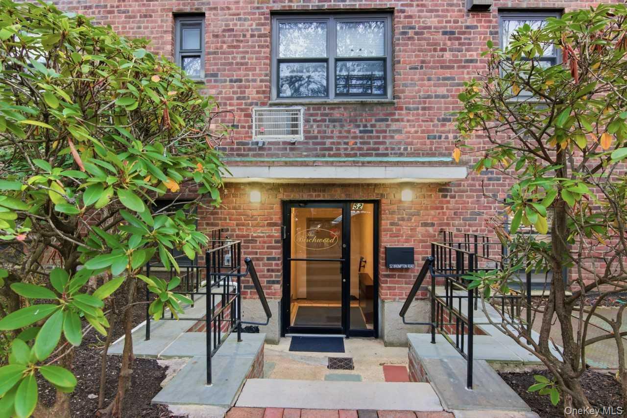 52 Brompton Road, Unit 52 Great Neck, NY 11021 - Photo 2 of 17 a front view of a house with glass windows and door