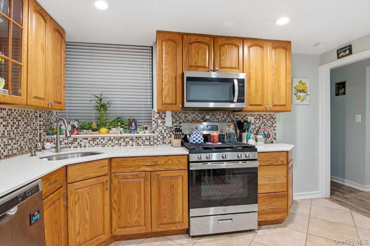 52 Brompton Road, Unit 52 Great Neck, NY 11021 - Photo 10 of 17 a kitchen with granite countertop cabinets stainless steel appliances and a sink