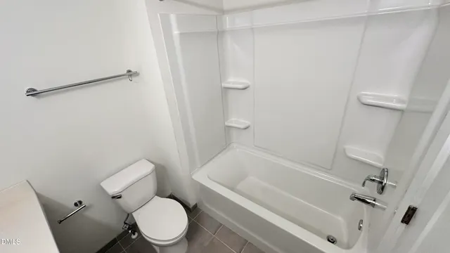 a white toilet sitting next to a bath tub