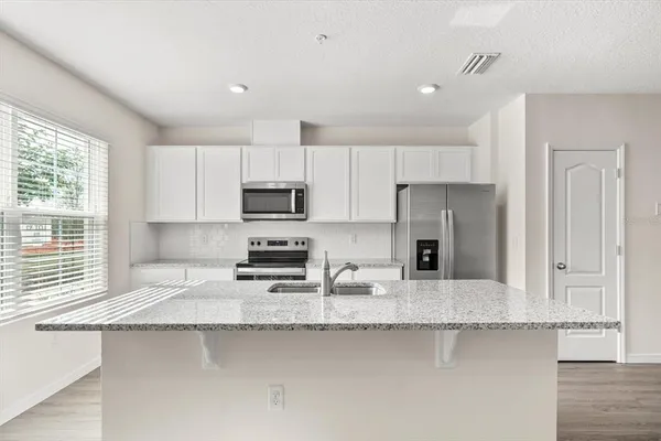a kitchen with a sink cabinets and wooden floor