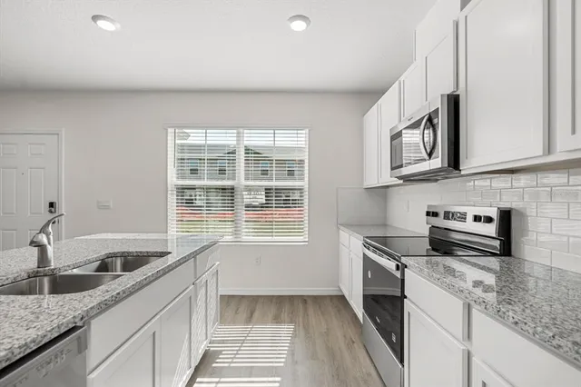 a view of a kitchen with wooden floor and a sink