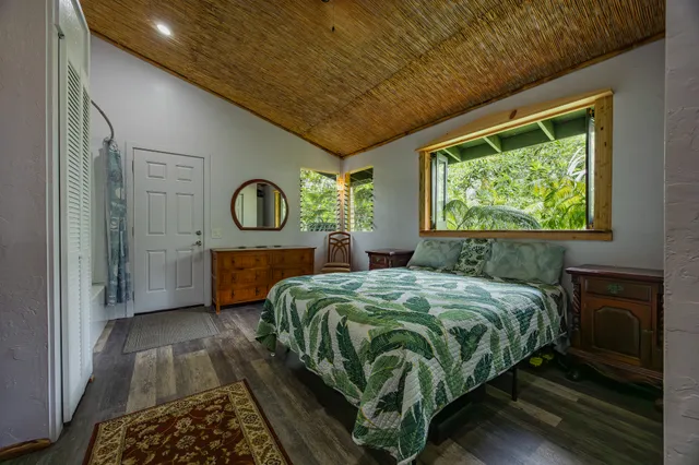 a bedroom with a bed mirror and window