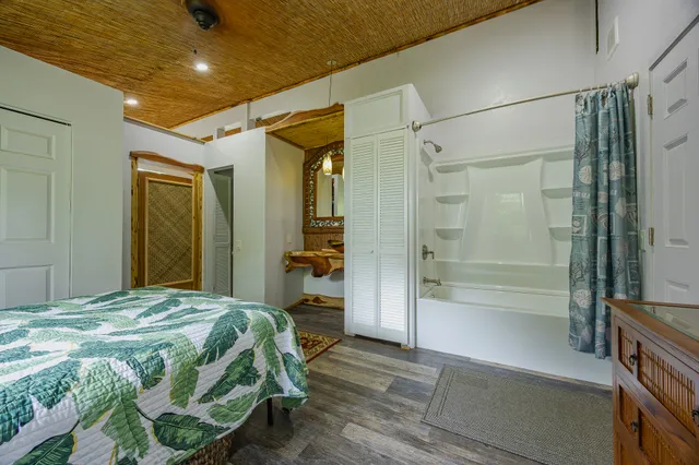 a bedroom with a bed and a glass door shower