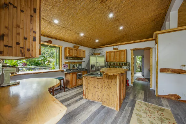 a living room with furniture a large window and wooden floors