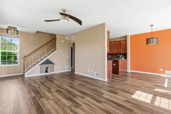a view of a kitchen with wooden floor and a ceiling fan