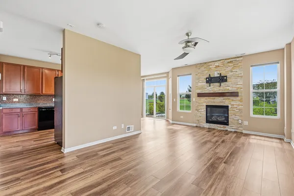 a view of a livingroom with wooden floor a fireplace and window
