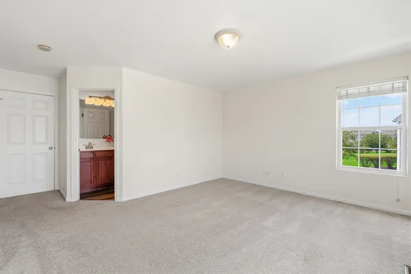 an empty room with a window and a bathroom