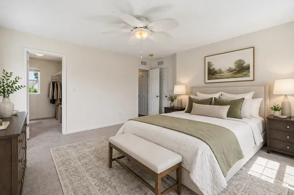 a spacious bedroom with a bed and a chandelier