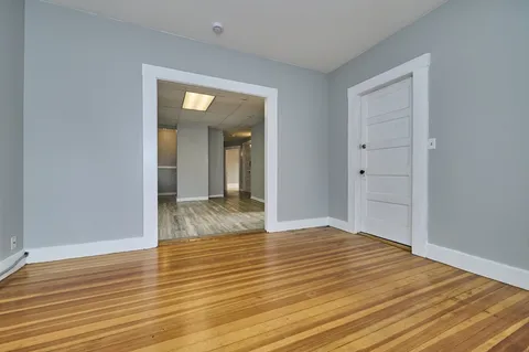 a view of an empty room with wooden floor