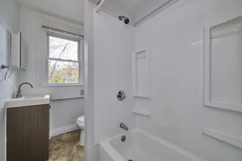 a bathroom with a sink a toilet and shower
