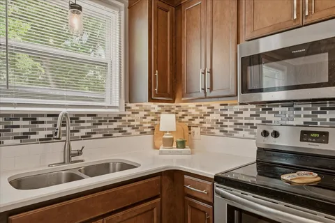 a kitchen with granite countertop a sink stove and cabinets