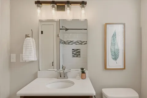 a bathroom with a toilet sink and mirror
