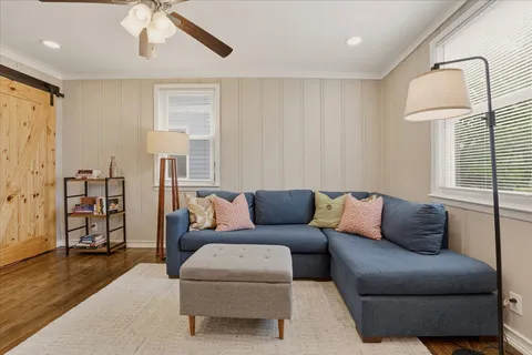 a living room with furniture and a wooden floor