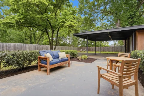 a view of patio with a table and chairs under an umbrella