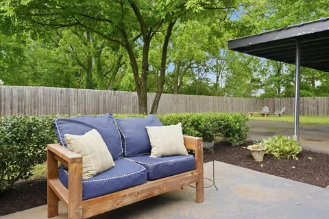 a view of a chair and table in the backyard
