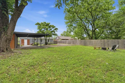a house with green field in front of it