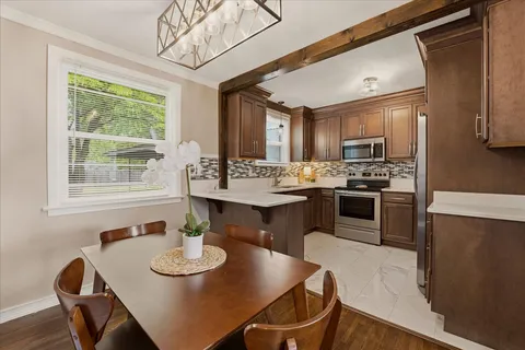 a kitchen with a table chairs stove and refrigerator