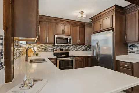 a kitchen with stainless steel appliances granite countertop a refrigerator stove top oven a sink and dishwasher