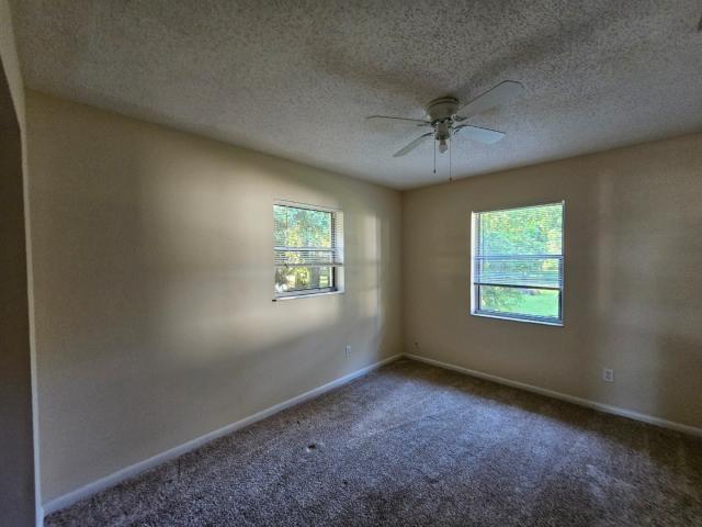 3261 Southwest 22nd Street Okeechobee, FL 34974 - Photo 13 of 15 an empty room with windows and fan