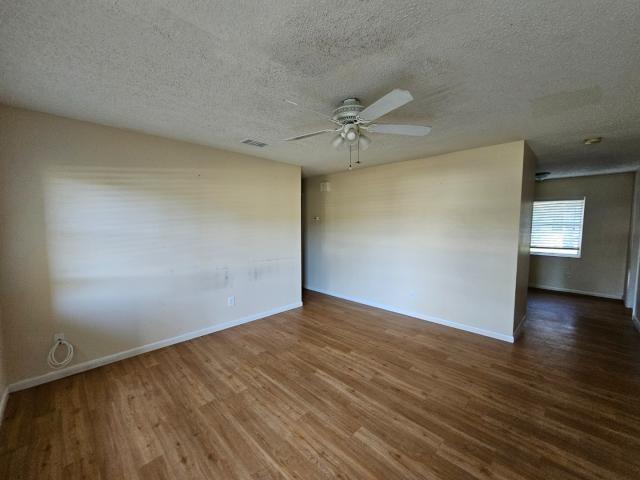 3261 Southwest 22nd Street Okeechobee, FL 34974 - Photo 3 of 15 a view of an empty room with wooden floor and a ceiling fan