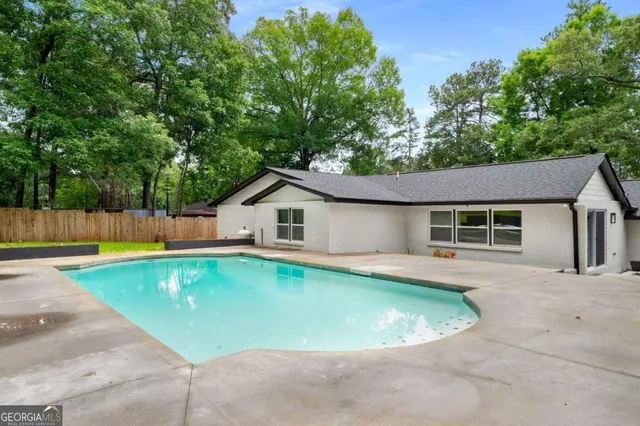 an aerial view of residential houses with outdoor space and trees
