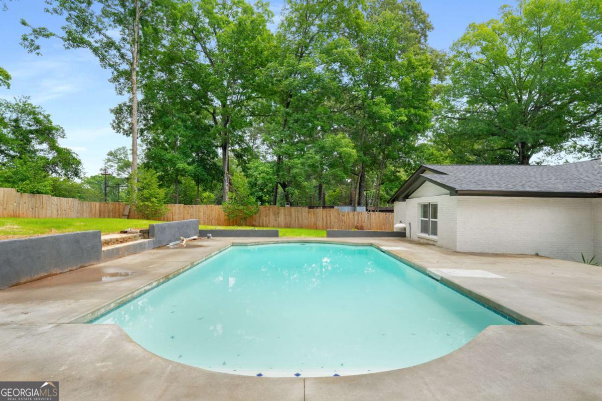 3154 North Druid Hills Road Decatur, GA 30033 - Photo 19 of 84 a view of a swimming pool with a yard and large trees