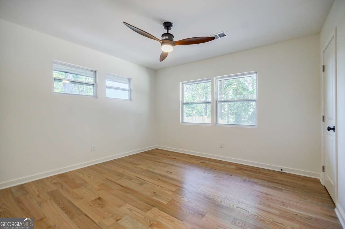 3154 North Druid Hills Road Decatur, GA 30033 - Photo 76 of 84 a view of empty room with wooden floor and fan