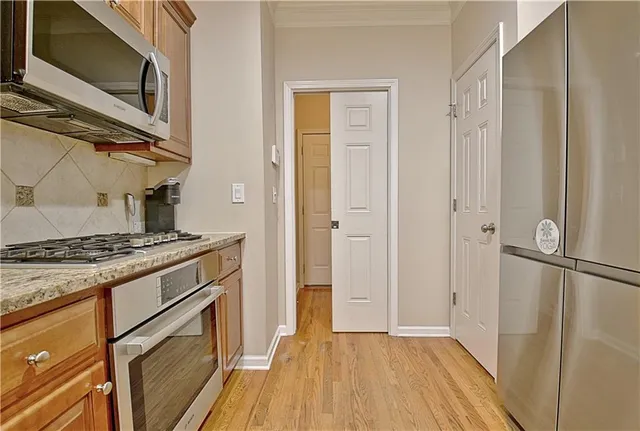 a kitchen with stainless steel appliances granite countertop a sink a stove and a wooden floors