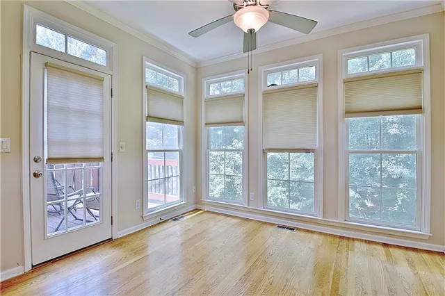 a view of an empty room with a window and wooden floor