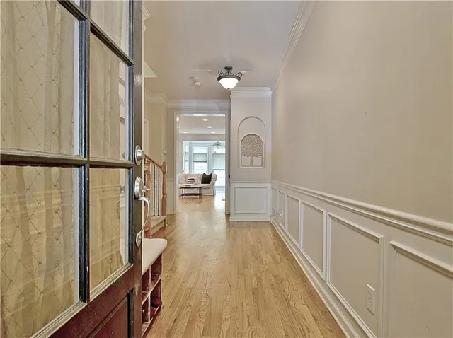 a view of a hallway with wooden floor and staircase