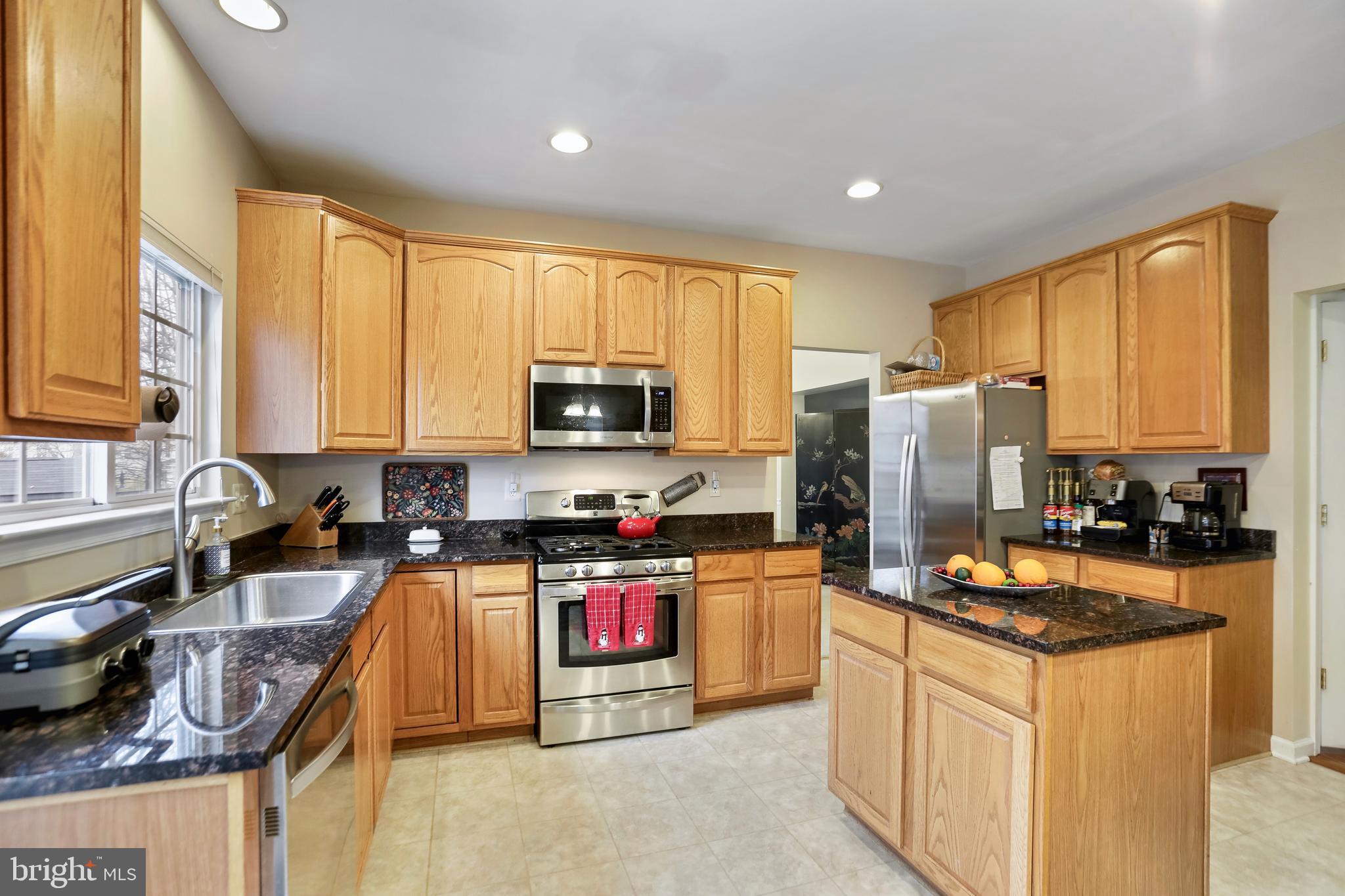 97 Webb Court Frederick, MD 21702 - Photo 11 of 34 a kitchen with granite countertop a stove top oven microwave and refrigerator