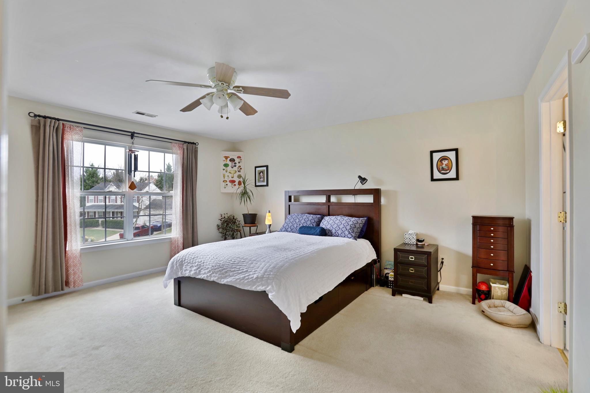 97 Webb Court Frederick, MD 21702 - Photo 22 of 34 a bedroom with a large bed and a chandelier fan