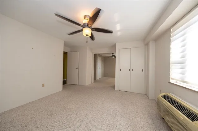 an empty room with closet and windows