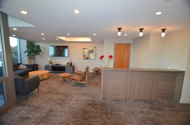 a living room with furniture kitchen view and a chandelier
